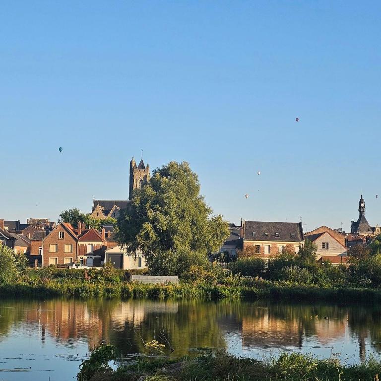 - une vue sur une ville avec une rivière et des maisons dans l'établissement La Petite Maison de la rue Fontaine Saint-Fursy, à Péronne