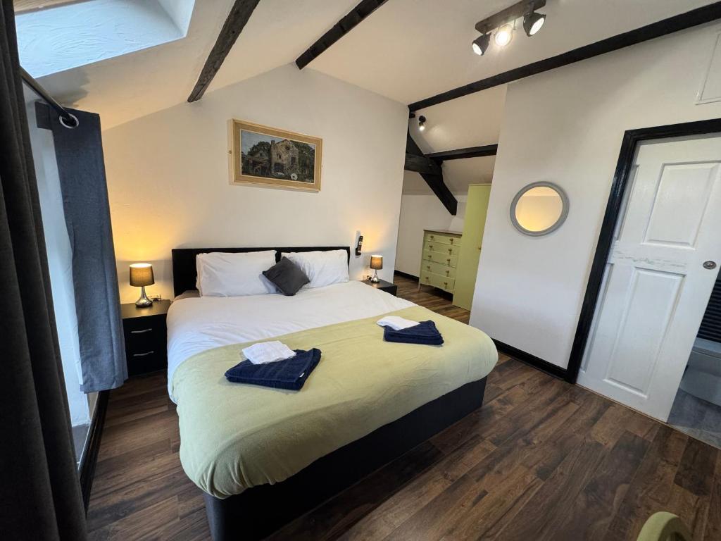 a bedroom with a bed with two towels on it at Penrhyn Cottage in Penrhyn Bay