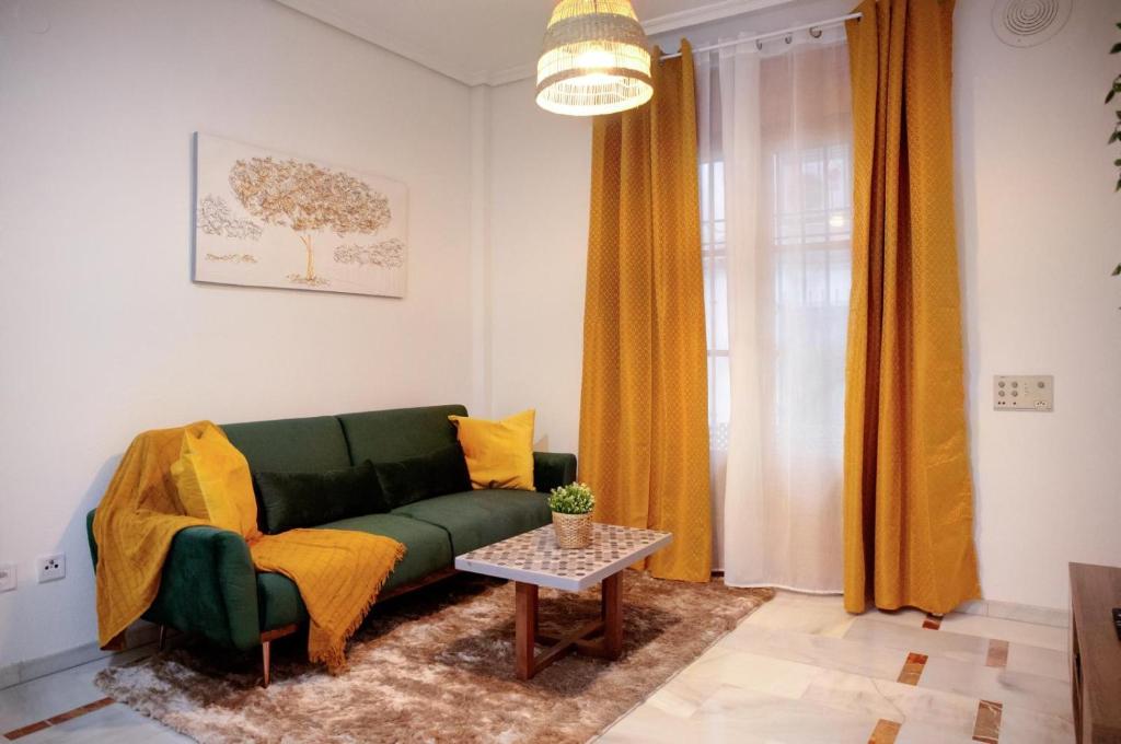 Una sala de estar con un sofá verde y una mesa. en El embrujo de Cordoba, en Córdoba