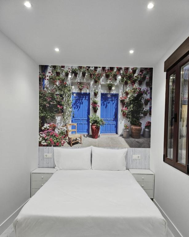 a white bedroom with a large white bed in it at Nueva PENSION CIBELES in Córdoba