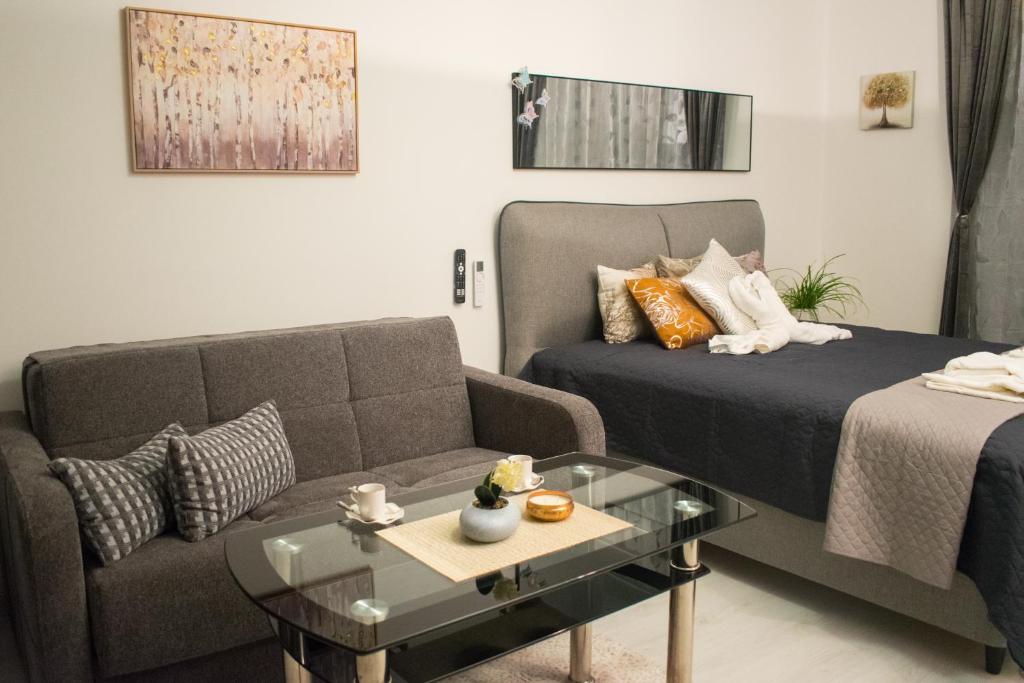 un soggiorno con un letto e un divano di Nelly's Place 10 a Shkorpilovtsi