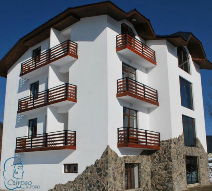 a white building with balconies on the side of it at Elite House in Bakuriani