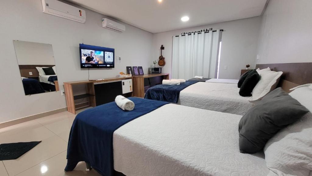 a hotel room with two beds and a flat screen tv at Loft1 suíte entrada privativa equipado, para até quatro pessoas a 4 minutos do aeroporto de Marabá in Marabá