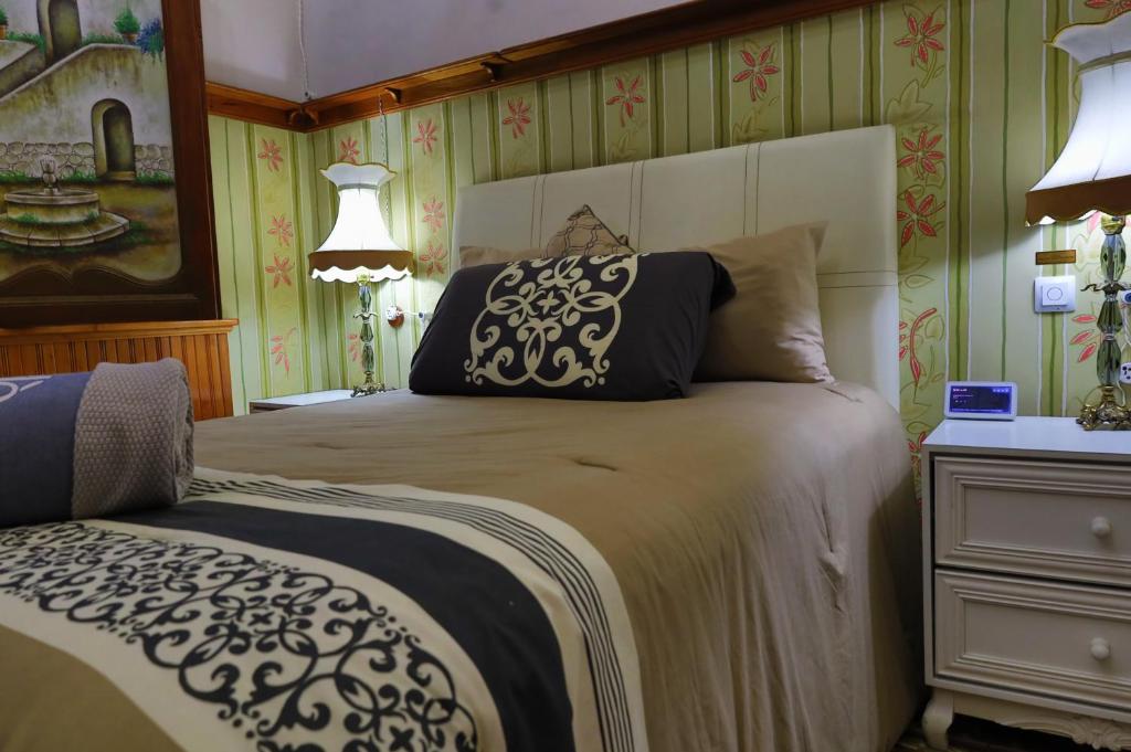 a bedroom with a bed and a dresser and lamps at Azcami Boutique Hotel in Puebla