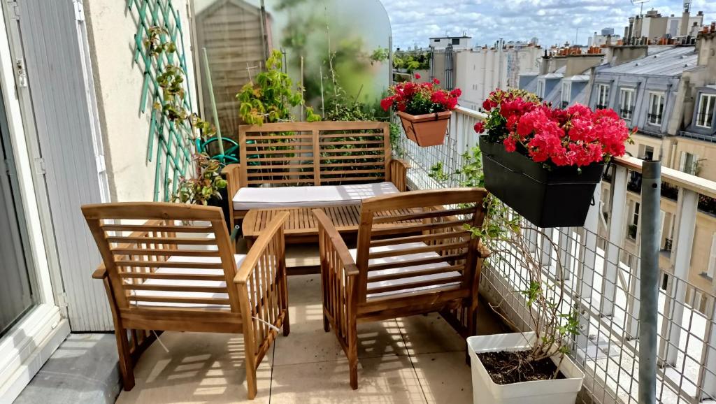 - un balcon avec une table, 2 chaises et des fleurs dans l'établissement Top Floor Appartement & Terrace with view, à Paris