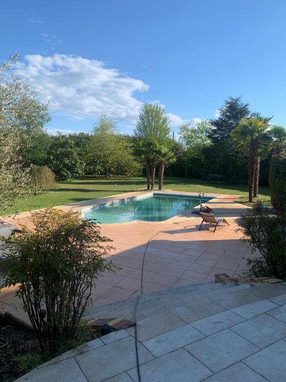 - une piscine avec un banc dans la cour dans l'établissement Villa Le Leard, à Allonnes