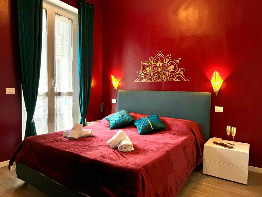 a red bedroom with a bed with towels on it at Milano Duomo Design Apartment in Milan