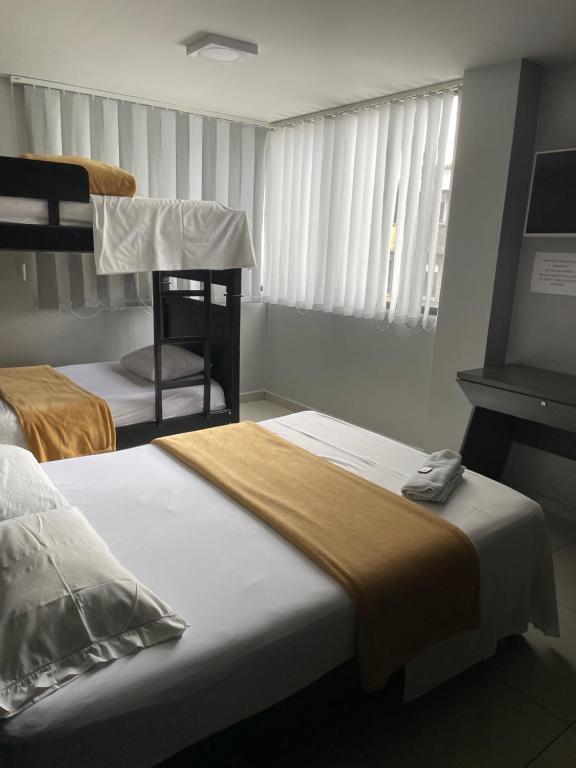 Postel nebo postele na pokoji v ubytování Hotel Escorial Ibagué