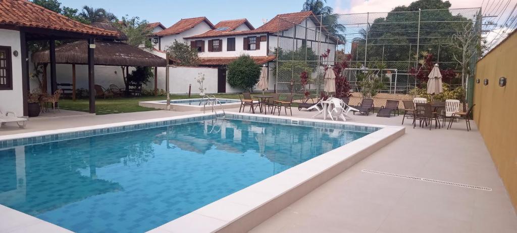a swimming pool in a yard with a house at Residence Geriba in Búzios