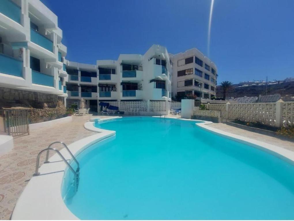 a large swimming pool in front of a building at New Puerto Rico Terrace Swiming Pool in Mogán