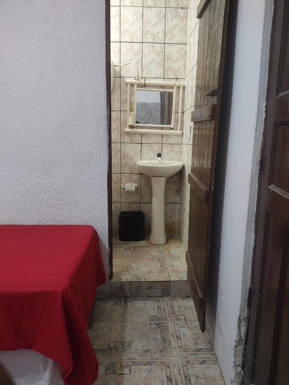 a bathroom with a sink and a mirror and a toilet at Pousada Iansã in Vera Cruz de Itaparica