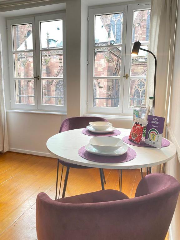 - une table avec deux chaises et une table avec des assiettes dans l'établissement Cosy Cathédrale, à Strasbourg
