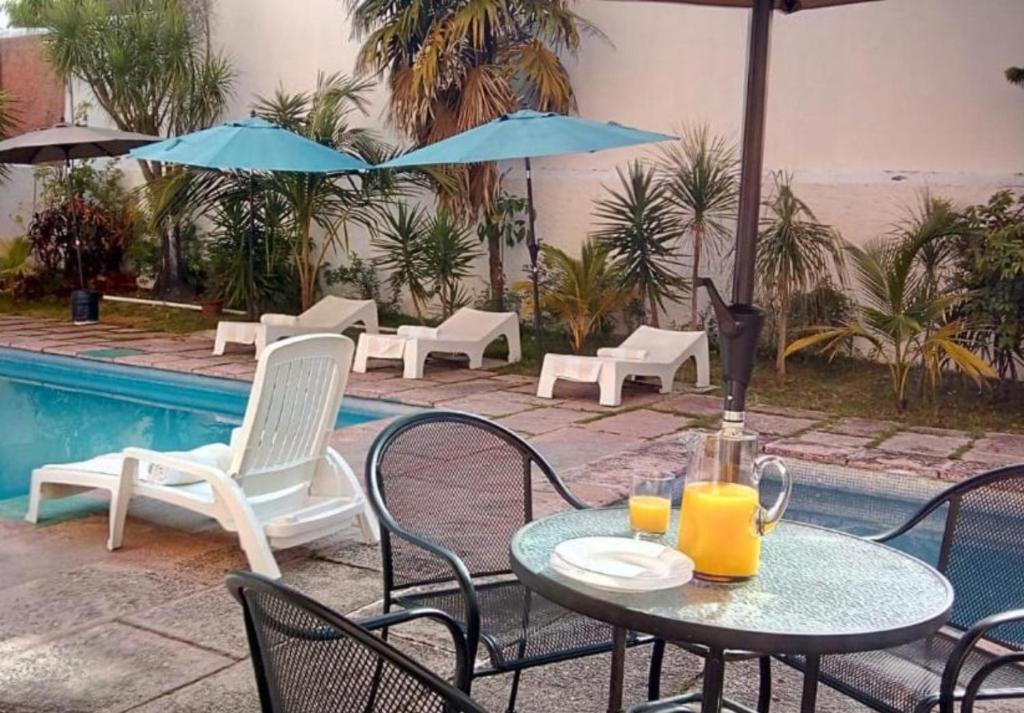 een tafel met drankjes naast een zwembad bij Íkaro Suites Cancún in Cancun