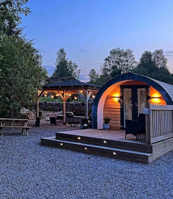 a gazebo with a table and a bench at Loch Ness Pods in Fort Augustus