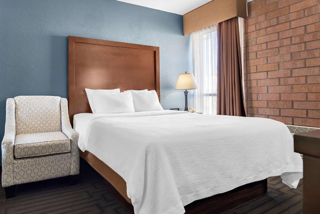 a hotel room with a large bed and a chair at Best Western Pocatello Inn in Pocatello