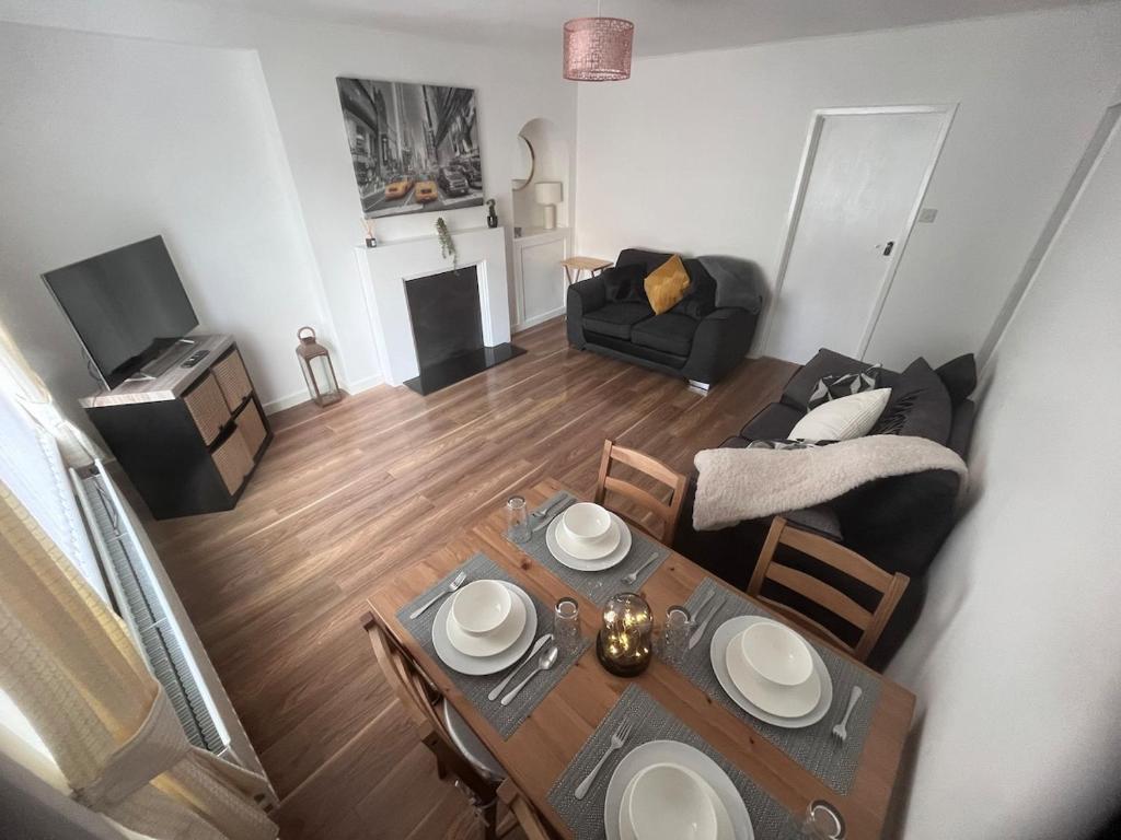 vistas panorámicas a una sala de estar con mesa y sofá en Mitchell House, en Bellshill