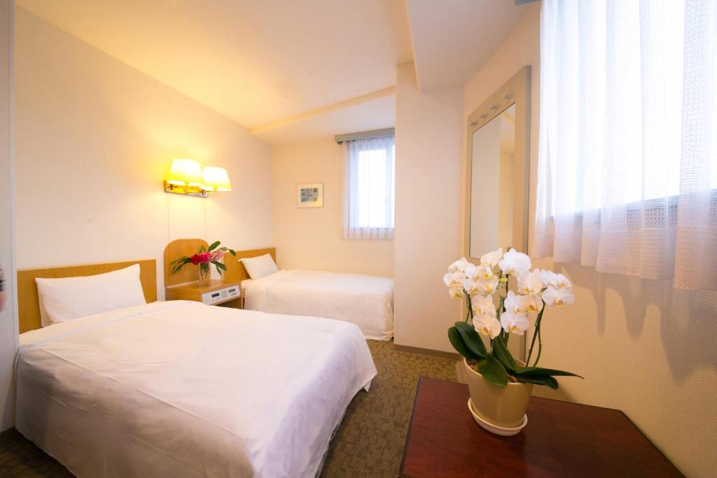 En eller flere senge i et værelse på Hotel Meijiya