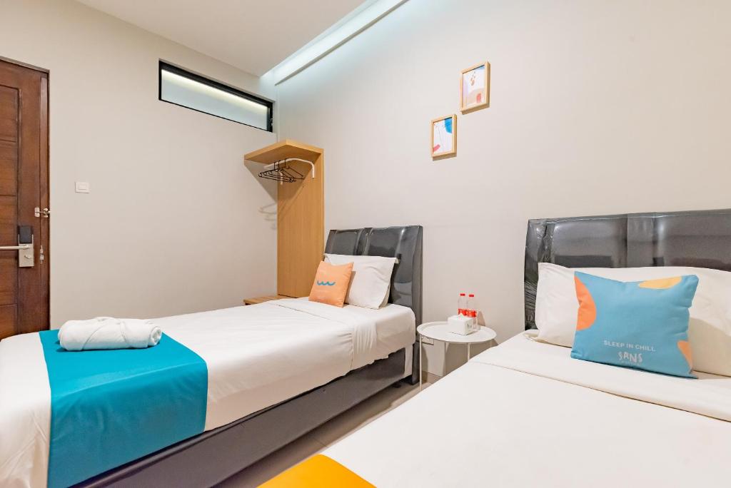 Postel nebo postele na pokoji v ubytování Sans Hotel Bobosini Malang by RedDoorz