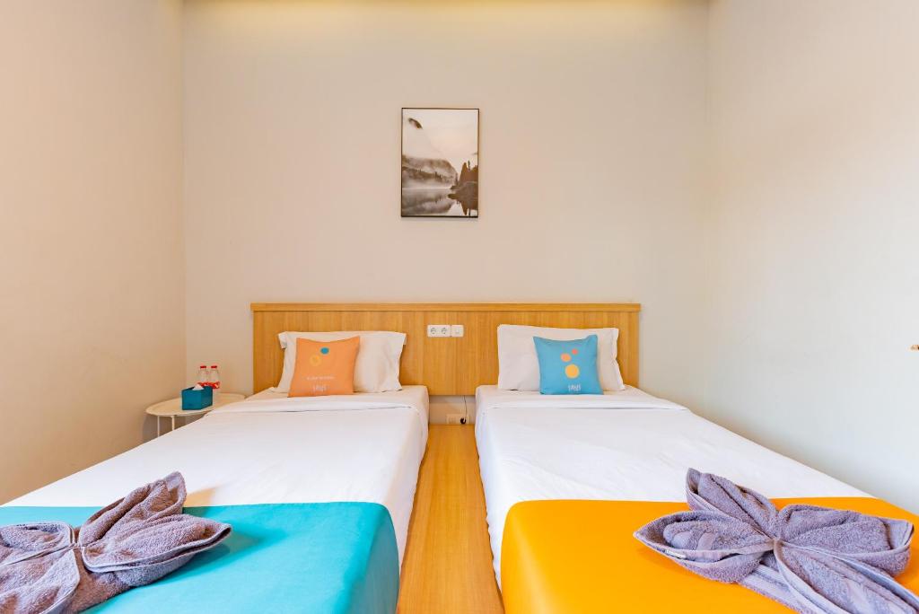 Postel nebo postele na pokoji v ubytování Sans Hotel Bobosini Malang by RedDoorz