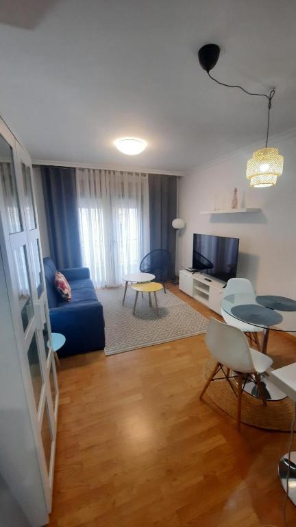 a living room with a blue couch and a table at Apartamento auditorio centro in Ribeira