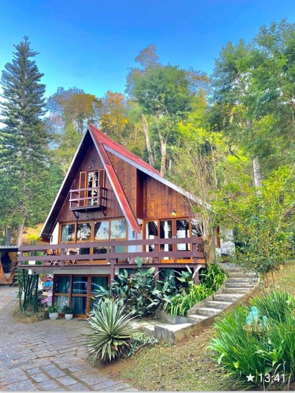 a large wooden house with stairs in front of it at Chalé Duzé Itaipava in Itaipava