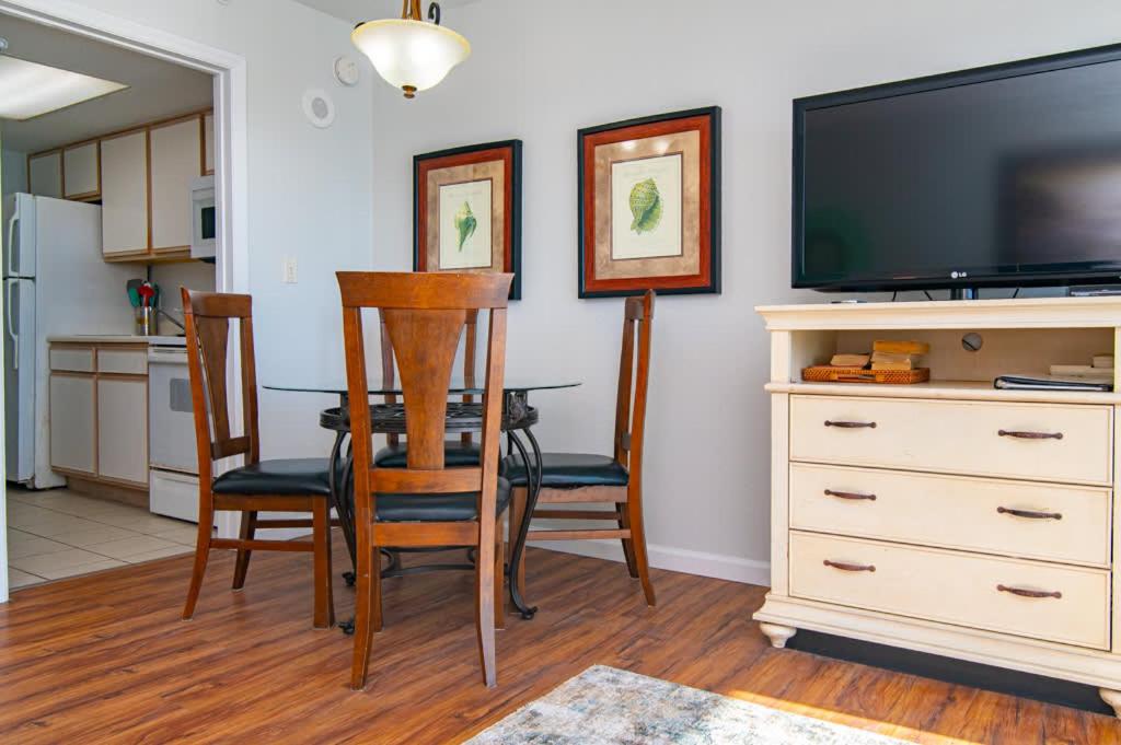 a living room with a dining room table and a television at Oceanfront TOP LOCATION MODERN RESORT Lazy River Huge Pool Oasis in Myrtle Beach