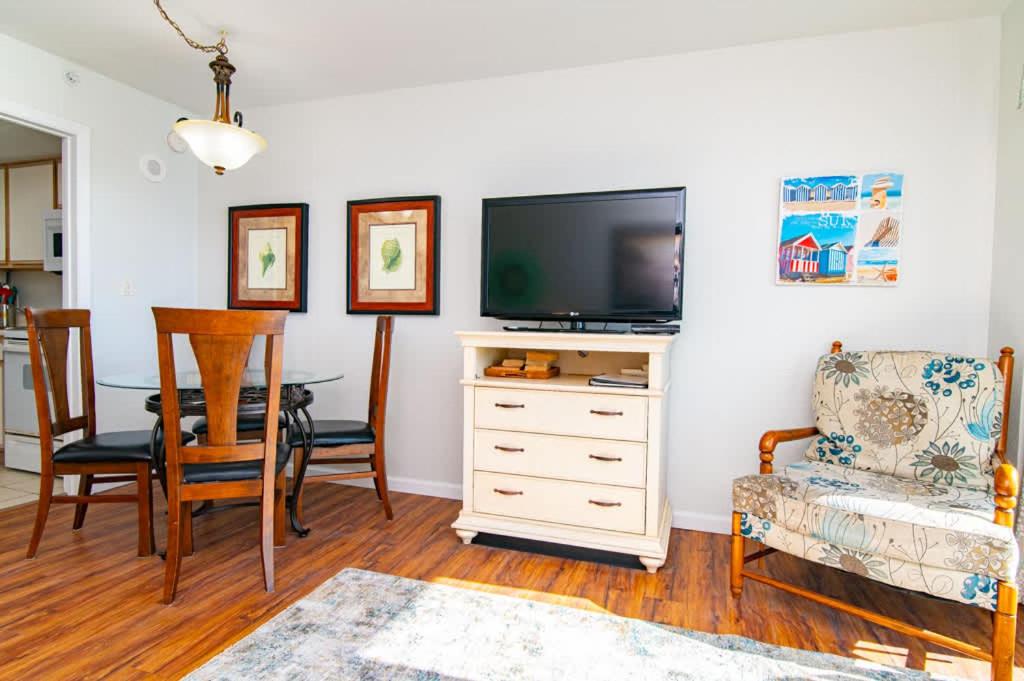 a living room with a television and a table and chairs at Oceanfront TOP LOCATION MODERN RESORT Lazy River Huge Pool Oasis in Myrtle Beach