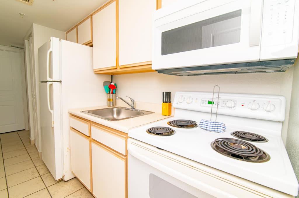 a kitchen with a white stove top oven next to a sink at Oceanfront TOP LOCATION MODERN RESORT Lazy River Huge Pool Oasis in Myrtle Beach