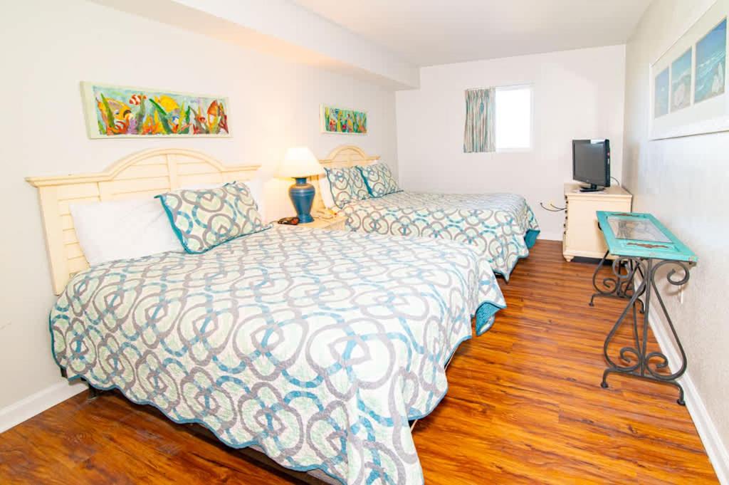 a bedroom with two beds and a television in it at Oceanfront TOP LOCATION MODERN RESORT Lazy River Huge Pool Oasis in Myrtle Beach