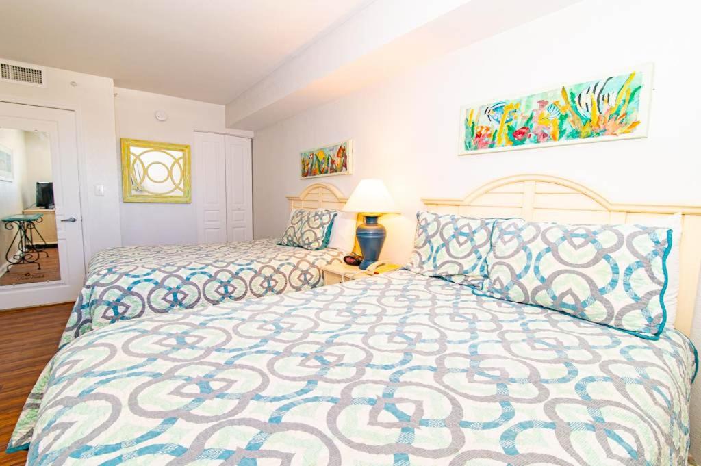 a bedroom with a large bed with a blue and white bedspread at Oceanfront TOP LOCATION MODERN RESORT Lazy River Huge Pool Oasis in Myrtle Beach
