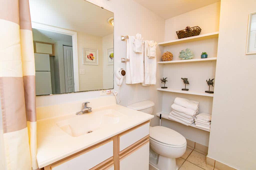 a bathroom with a sink and a toilet and a mirror at Oceanfront TOP LOCATION MODERN RESORT Lazy River Huge Pool Oasis in Myrtle Beach