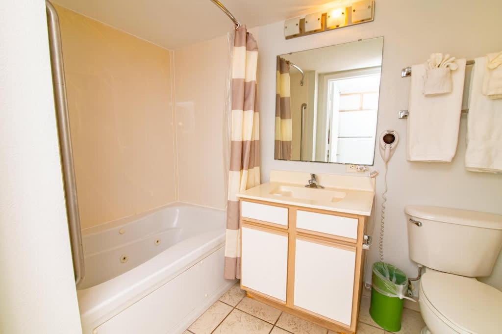 a bathroom with a tub and a sink and a toilet at Oceanfront TOP LOCATION MODERN RESORT Lazy River Huge Pool Oasis in Myrtle Beach