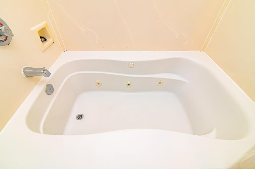 a white bath tub sitting in a bathroom at Oceanfront TOP LOCATION MODERN RESORT Lazy River Huge Pool Oasis in Myrtle Beach