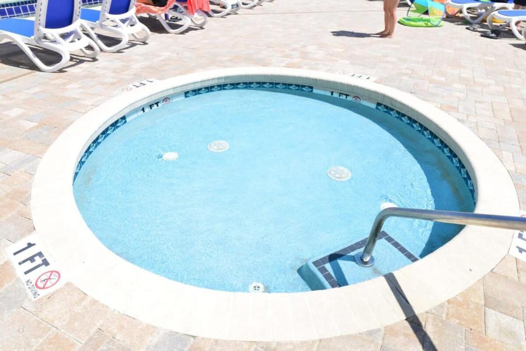 a large swimming pool with people sitting around it at Oceanfront TOP LOCATION MODERN RESORT Lazy River Huge Pool Oasis in Myrtle Beach