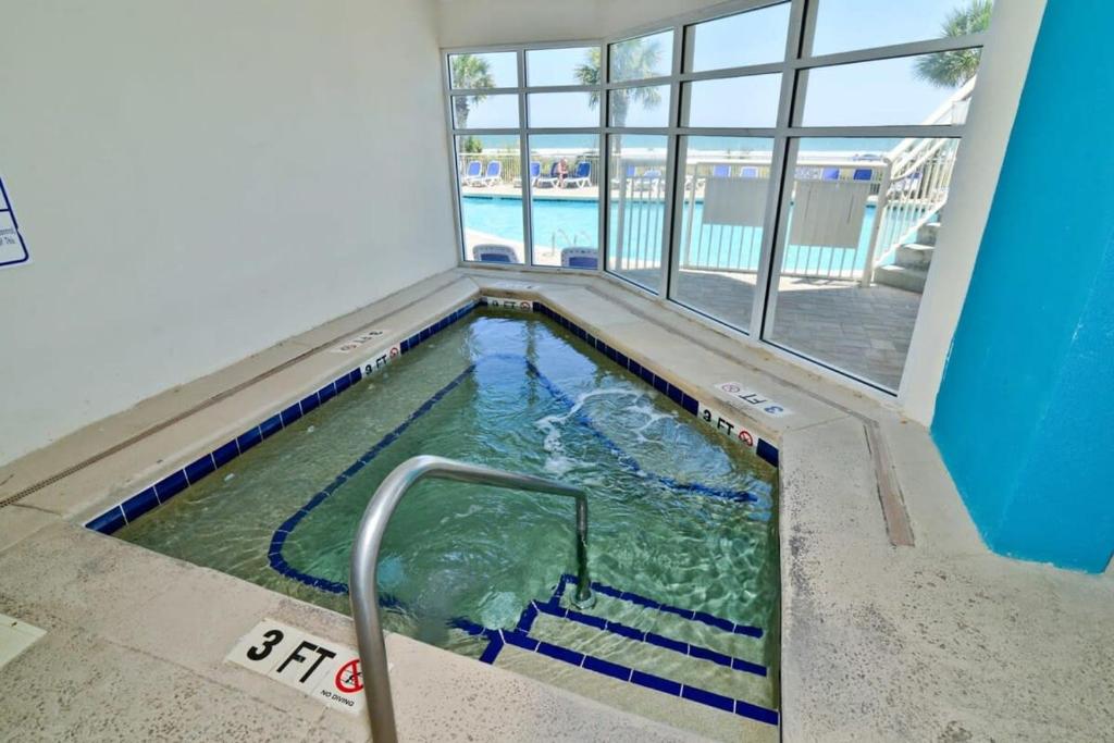 a small swimming pool in a room with a window at Oceanfront TOP LOCATION MODERN RESORT Lazy River Huge Pool Oasis in Myrtle Beach