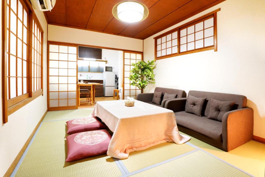 ein Wohnzimmer mit Tisch und Couch in der Unterkunft 和風庵Wafuna 7min walk to Teradacho Loop Line Station in Osaka