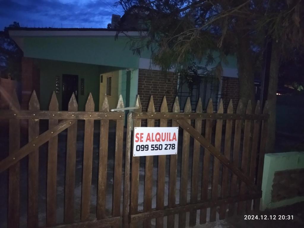a sign on a fence in front of a house at Casa ilusión in Artilleros