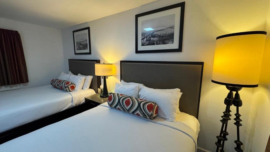 a hotel room with two beds and two lamps at Budget Motel in Gilroy