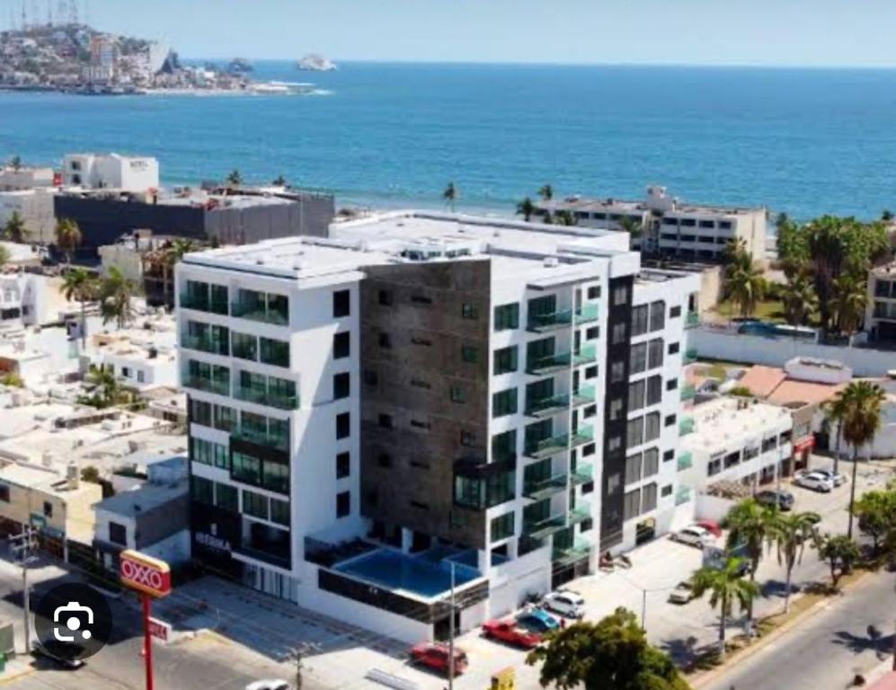 a large white building in front of the ocean at Departamento Torre Iberika Cercas Del Malecon in Mazatlán