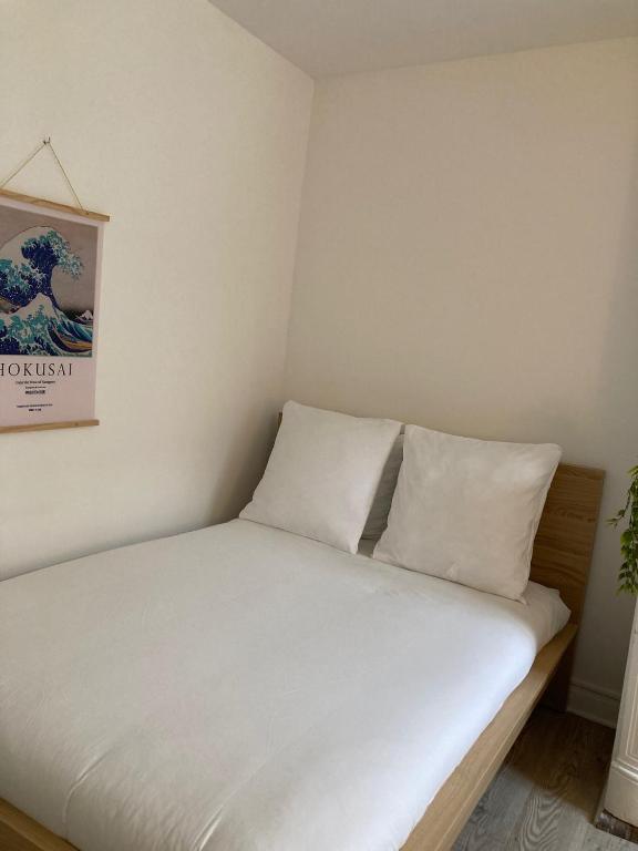 Ce lit se trouve dans un dortoir doté de draps et d'oreillers blancs. dans l'établissement Travel Tokyo, à Sens