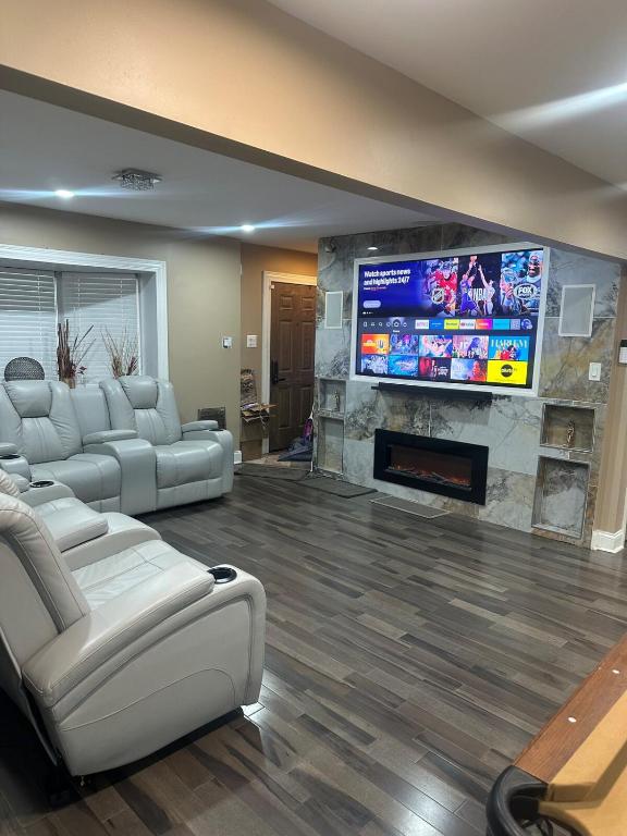 a living room with couches and a flat screen tv at The Marlowe, A Couples Getaway in Chicago