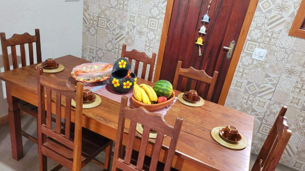 un tavolo di legno con una ciotola di frutta sopra di Casa Rústica Próxima ao Distrito de Milho Verde, 3 QUARTOS - São Gonçalo do Rio das Pedras, Serro a Sêrro