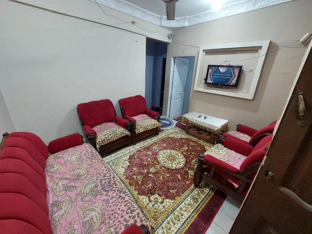 ein Wohnzimmer mit roten Stühlen und einem Teppich in der Unterkunft شقه مفروشه جميله جدا بموقع متميز 1 in Kairo