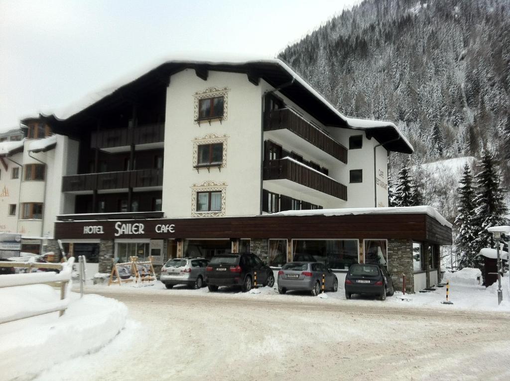 un gran edificio con coches estacionados frente a él en Hotel Sailer en Sankt Anton am Arlberg