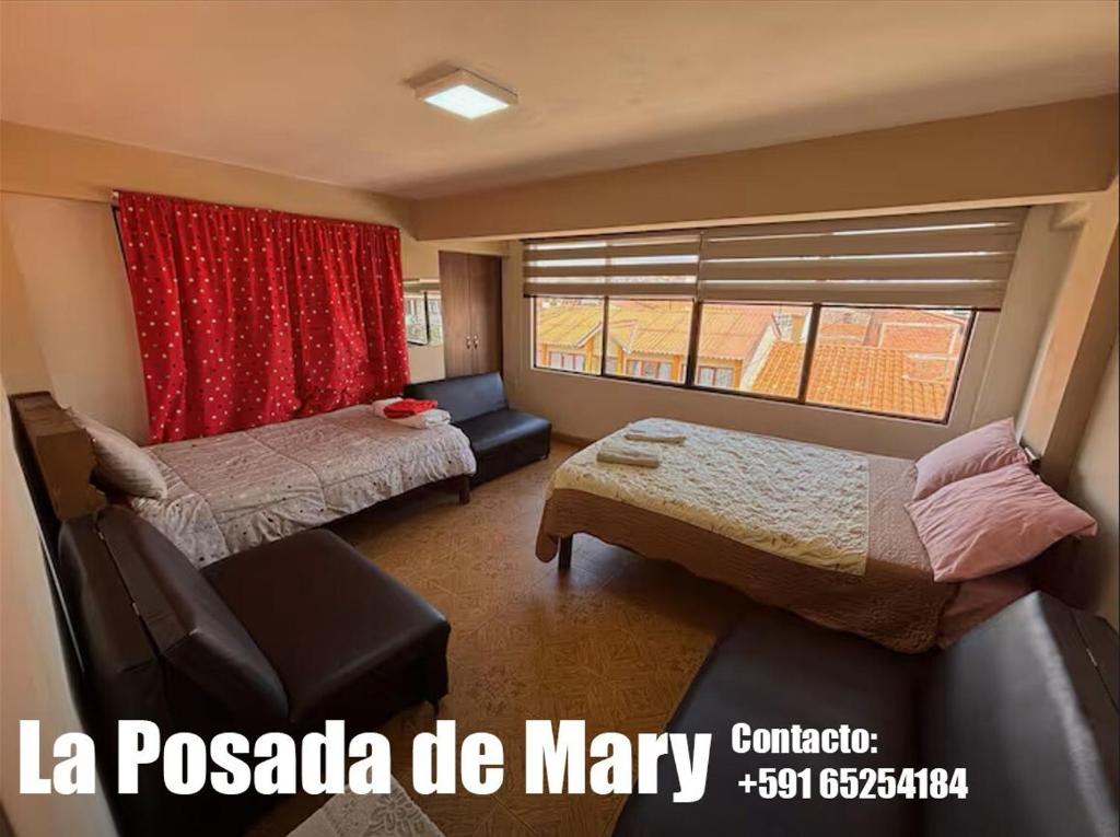 a room with two beds and a couch and a window at La Posada de Mary Departamento 1 in Sucre