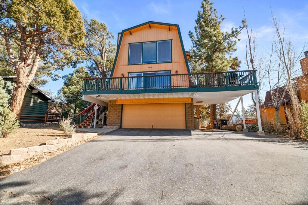ein Haus mit einem Balkon über einer Auffahrt in der Unterkunft The Cedar Bear Lodge, Jacuzzi with an Outdoor Patio & BBQ in Big Bear City Airport