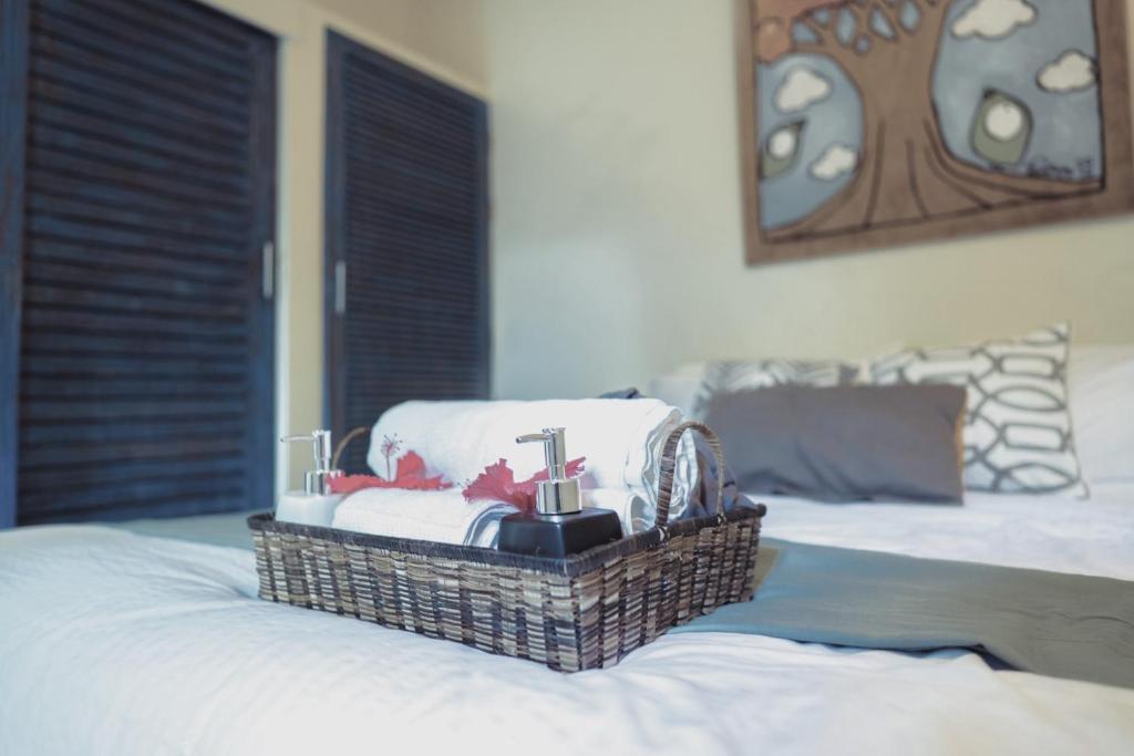 a basket filled with towels on top of a bed at Sleepy Gypsea Villa Siargao - Diamond in Catagnan