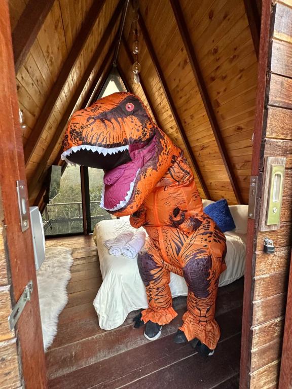 a large dinosaur statue sitting on a bed in a room at Glampling Dos Quebradas in Floridablanca