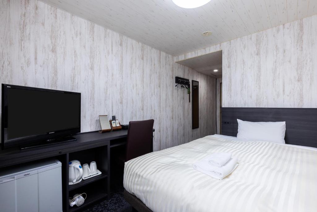 a bedroom with a bed and a flat screen tv at Select Inn Fujisan Gotemba in Gotemba