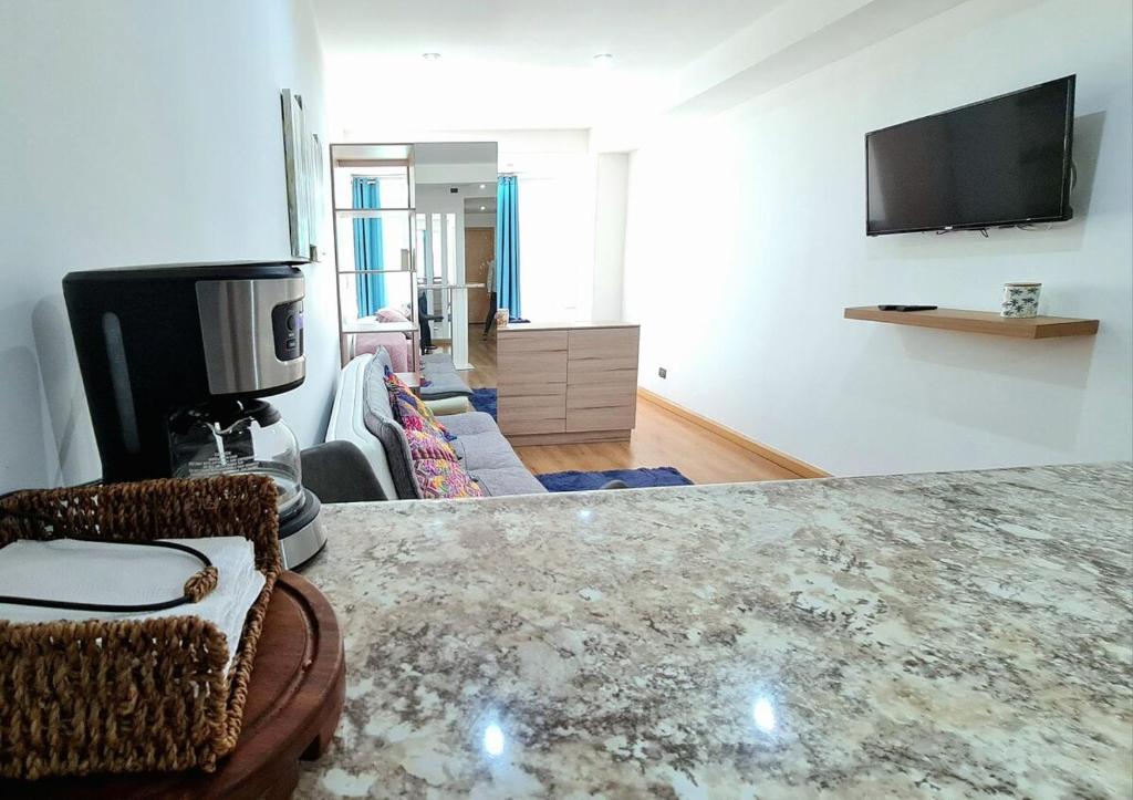 ein Wohnzimmer mit einem Sofa und einem TV an der Wand in der Unterkunft Modern Loft 511 in Centro Historico Centro Vivo in Las Victorias